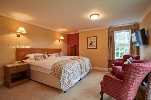 um quarto de hotel com uma cama e uma cadeira em Sid Valley Country House Hotel em Sidmouth