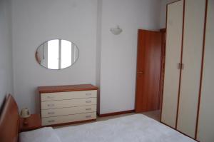 une chambre avec une commode et un miroir dans l'établissement La finestra sul parco, à Vérone