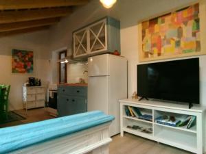 a kitchen with a white refrigerator and a tv at Apartments Jago in Piran