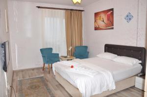 ein Schlafzimmer mit einem Bett und zwei blauen Stühlen in der Unterkunft KAT11 in Beylikdüzü