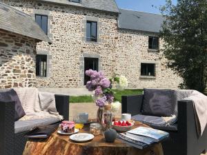 Clos l'Abbe, Piscine & Spa - Demeure de Prestige في Ouville: فناء مع طاولة و كرسيين و ورد