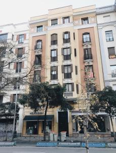 un bâtiment situé dans une rue avec des arbres devant elle dans l'établissement Reina Victoria 46, à Madrid