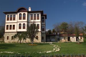 a large building with a grass yard in front of it at Pacacioglu Bag Evi in Safranbolu