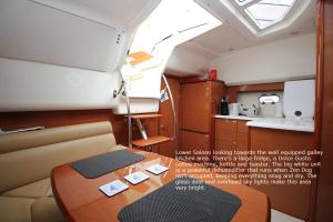 a small room with a table and a kitchen at Zen Dog Luxury Motor Yacht in Lymington