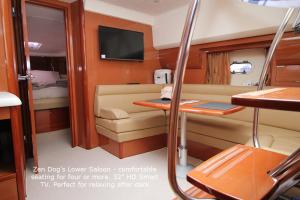 a small room with a couch and a tv on a boat at Zen Dog Luxury Motor Yacht in Lymington