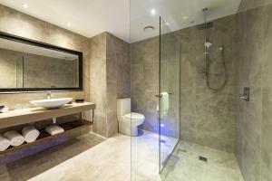 La salle de bains est pourvue d'une douche, de toilettes et d'un lavabo. dans l'établissement Distinction Christchurch Hotel, à Christchurch