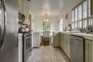 a large kitchen with white cabinets and a large island at A Touch of Cape Cod in West Hollywood in Los Angeles