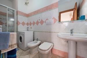 bagno con servizi igienici, lavandino e specchio di Casa Nancy ad Amalfi