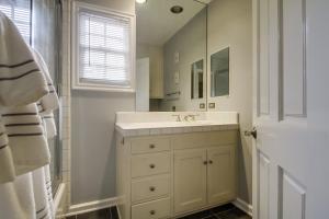 a white bathroom with a sink and a mirror at A Touch of Cape Cod in West Hollywood in Los Angeles