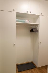 a closet with white cabinets and a glass door at Modernes Studio im Herzen von Neustadt: PfalzLiebe in Neustadt an der Weinstraße
