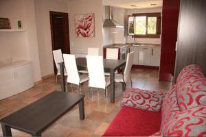 een woonkamer met een tafel en stoelen en een keuken bij Apartamento Angel e Isabel in Alquézar