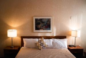 una camera d'albergo con un letto con due lampade di Royal Inn and Suites at Guelph a Guelph