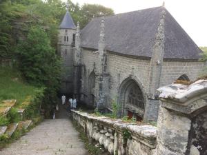an old church with people standing outside of it at L' écrin de Pradou Glas in Le Saint