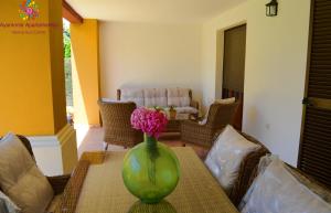 a green vase with a flower on a table at MARINA AZUL GOLF in Ayamonte