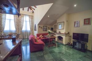 a living room with a red couch and a fireplace at LA ATALAYA GREAT LUXURY ATTIC in Antequera