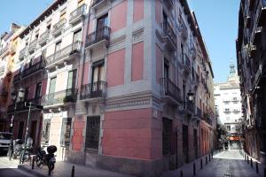 un edificio rosa e bianco su una strada cittadina di DONES Apartamento en el Casco Histórico de Zaragoza a Saragozza