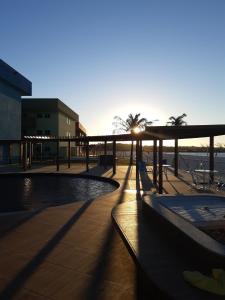 einen Sonnenuntergang über einem Pool in einem Gebäude mit Sonnenuntergang in der Unterkunft GOLDEN LAKE RESIDENCE in Arraial do Cabo