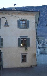 a building with green shutters and a window at Parravicini Red Flower apartment in Tirano