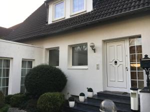a white house with a white door and stairs at Düsseldorf Messe -Apartment Milan in Düsseldorf +13 photos