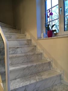 a white marble staircase in a home with a window at Düsseldorf Messe -Apartment Milan in Düsseldorf