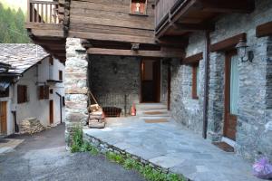 尚波呂克的住宿－Alle pendici del Monte Rosa，石头房子的入口,带木屋顶