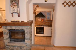 a kitchen with a stone fireplace in a room at Alle pendici del Monte Rosa in Champoluc