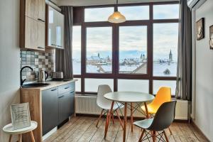 a kitchen with a table and chairs and a large window at Panorama studio in Sibiu
