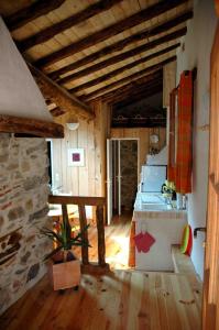 a room with a kitchen with a stone wall at Arcogite in Vicdessos