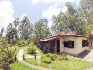a small house in the middle of a garden at Hotel Fazenda dos Anjos in Cambuquira