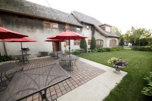 eine Terrasse mit Tischen und Sonnenschirmen im Hof in der Unterkunft Leonard at Logan House in Grand Rapids