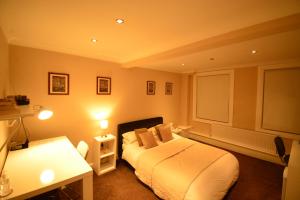 a bedroom with a white bed and a desk and lamp at Aparthotel Glovers Court in Preston