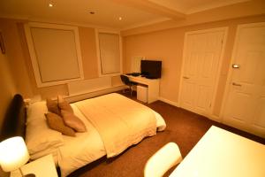a bedroom with a bed and a desk with a computer at Aparthotel Glovers Court in Preston