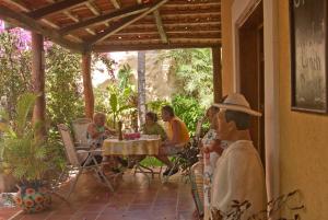 a group of people sitting at a table on a patio at Hotel La Joya Isla Mujeres in Isla Mujeres