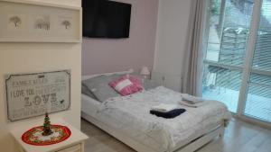 sypialnia z łóżkiem i oknem w obiekcie Apartament Lux Monika Rewal z tarasem i garażem w Rewalu