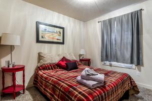 ein Schlafzimmer mit einem Bett mit einer roten Decke und einem Fenster in der Unterkunft Gray Cloud Townhomes in Meridian