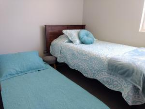 1 dormitorio con 2 camas con almohadas azules en Departamento La Herradura, Coquimbo, en Coquimbo