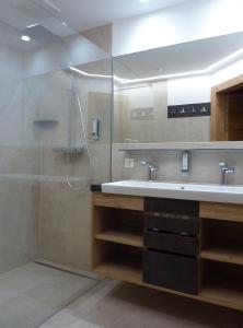 ein Bad mit einem Waschbecken und einer Dusche in der Unterkunft Aparthotel Bernhof in Obertauern