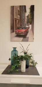 ein Bild eines roten Autos und zwei Pflanzen auf dem Tisch in der Unterkunft Deluxapartment in Kaiserslautern