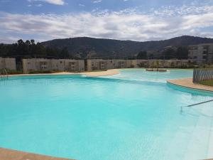una grande piscina di acqua blu con edifici sullo sfondo di Departamento en Lomas de Papudo II a Papudo Altre 20 foto