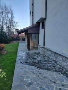 a house with a stone walkway next to a building at Mountain Escape Bansko 1BR apartment in Bansko +5 photos