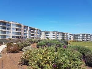 un gran edificio de apartamentos con un jardín de plantas en Departamento en Lomas de Papudo II, en Papudo