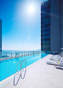 una piscina en la azotea de un edificio con el océano en Kolon Seacloud Hotel, en Busan