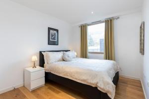 um quarto com uma cama grande e uma janela em East Croydon Apartments - Just 3 mins walk to East Croydon station em Croydon