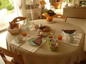 una mesa con un mantel blanco con comida. en Chambre d'Hotes Pause en Chemin, en Condette
