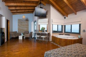 a bedroom with a tub and a tv in a room at Ramot Resort Hotel in Moshav Ramot