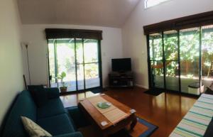 uma sala de estar com um sofá e uma mesa de centro em Byron Beach Cabin em Byron Bay