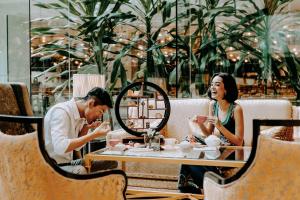 a man and woman sitting at a table in a restaurant at Shangri-La Kuala Lumpur in Kuala Lumpur +128 photos