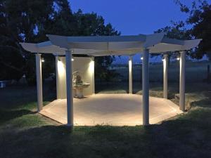 a pavilion with lights in a park at night at The Gatehouse at Villa Raedward in Yering