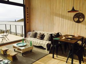 PUPUYA LODGE cabaña A, Matanzas في ماتانزاس: غرفة معيشة مع طاولة وأريكة