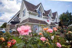 una casa con flores delante en Rose Court Motel, en Rotorua